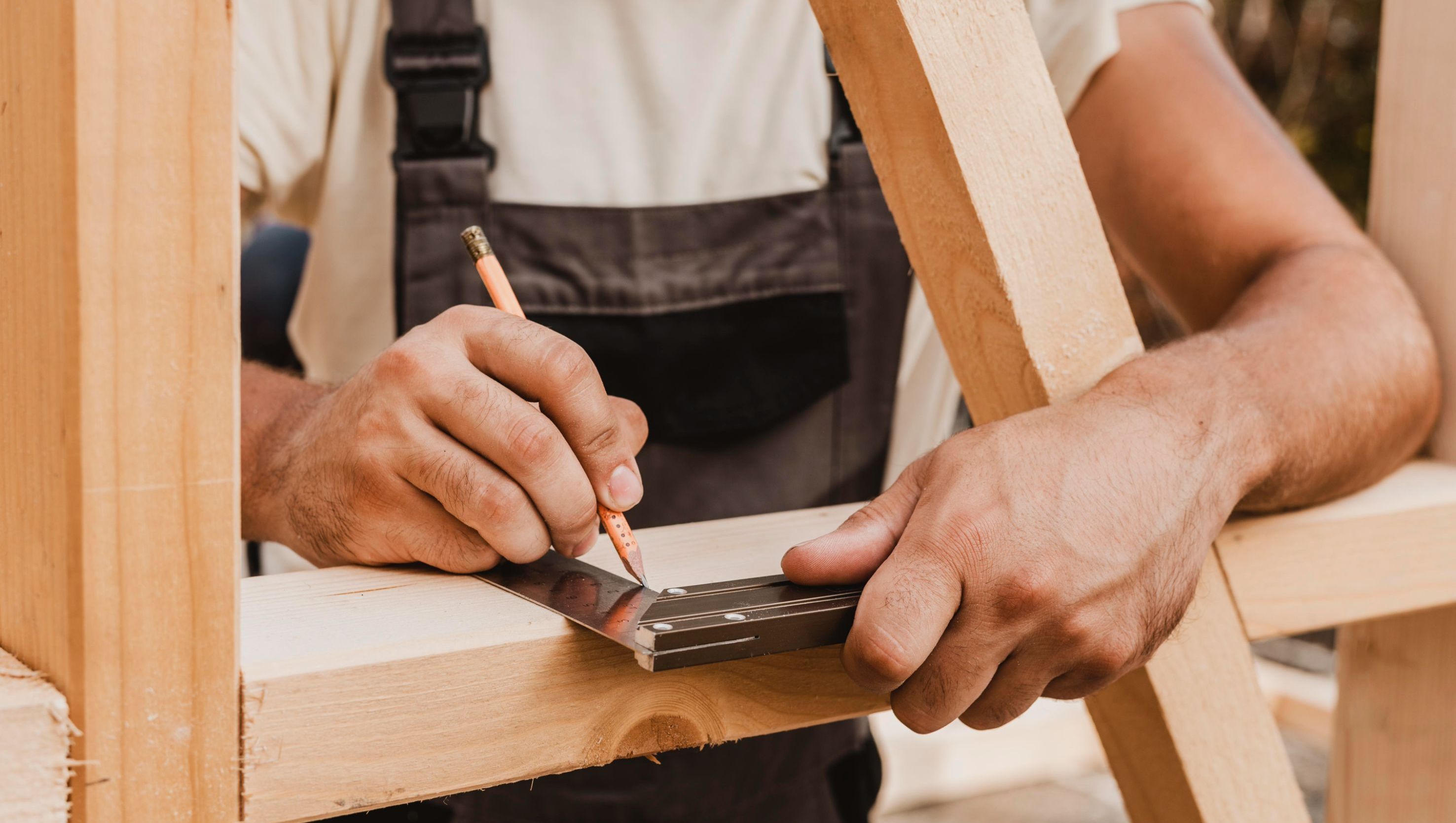 Snekker måler opp før kapp av plank
